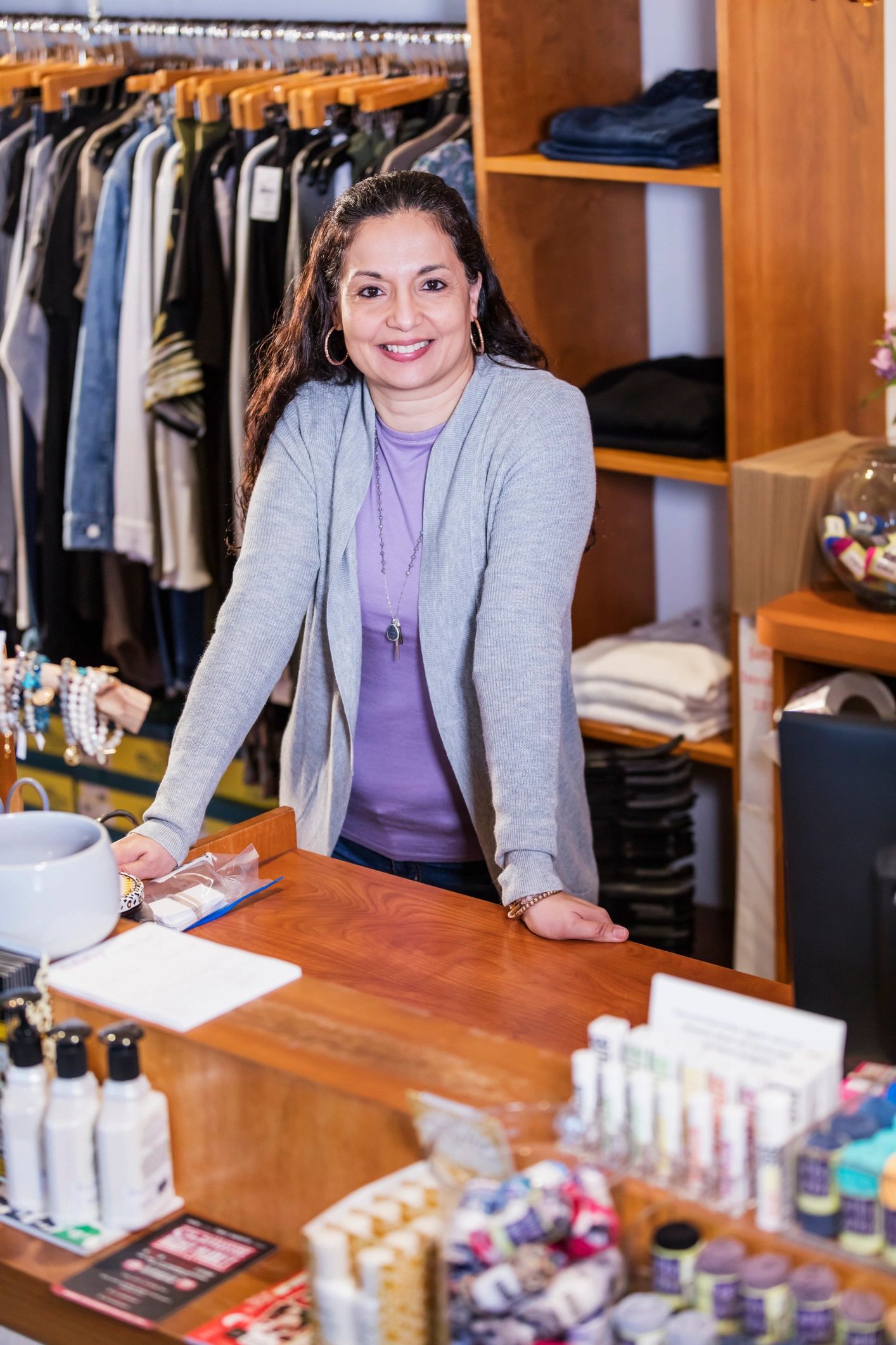Retail boutique owner smiling behind the counter