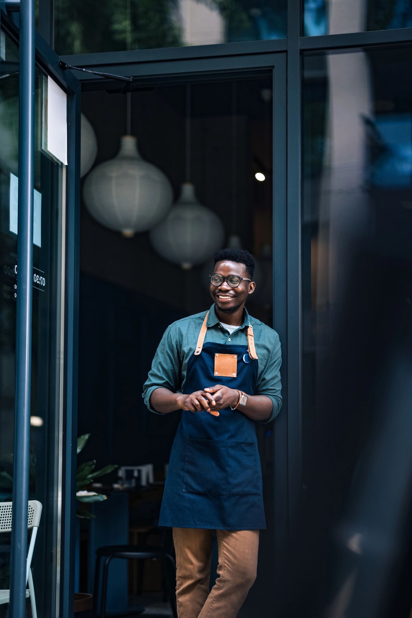 Retail business owner standing at the entrance of a small shop