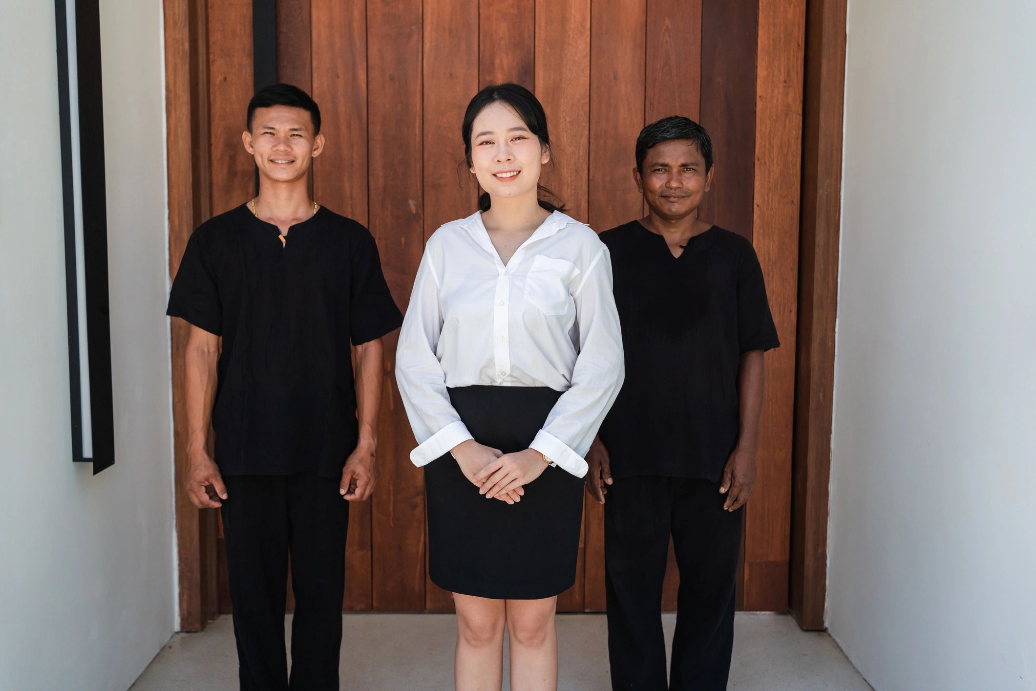 Hospitality staff welcoming guests at a hotel entrance