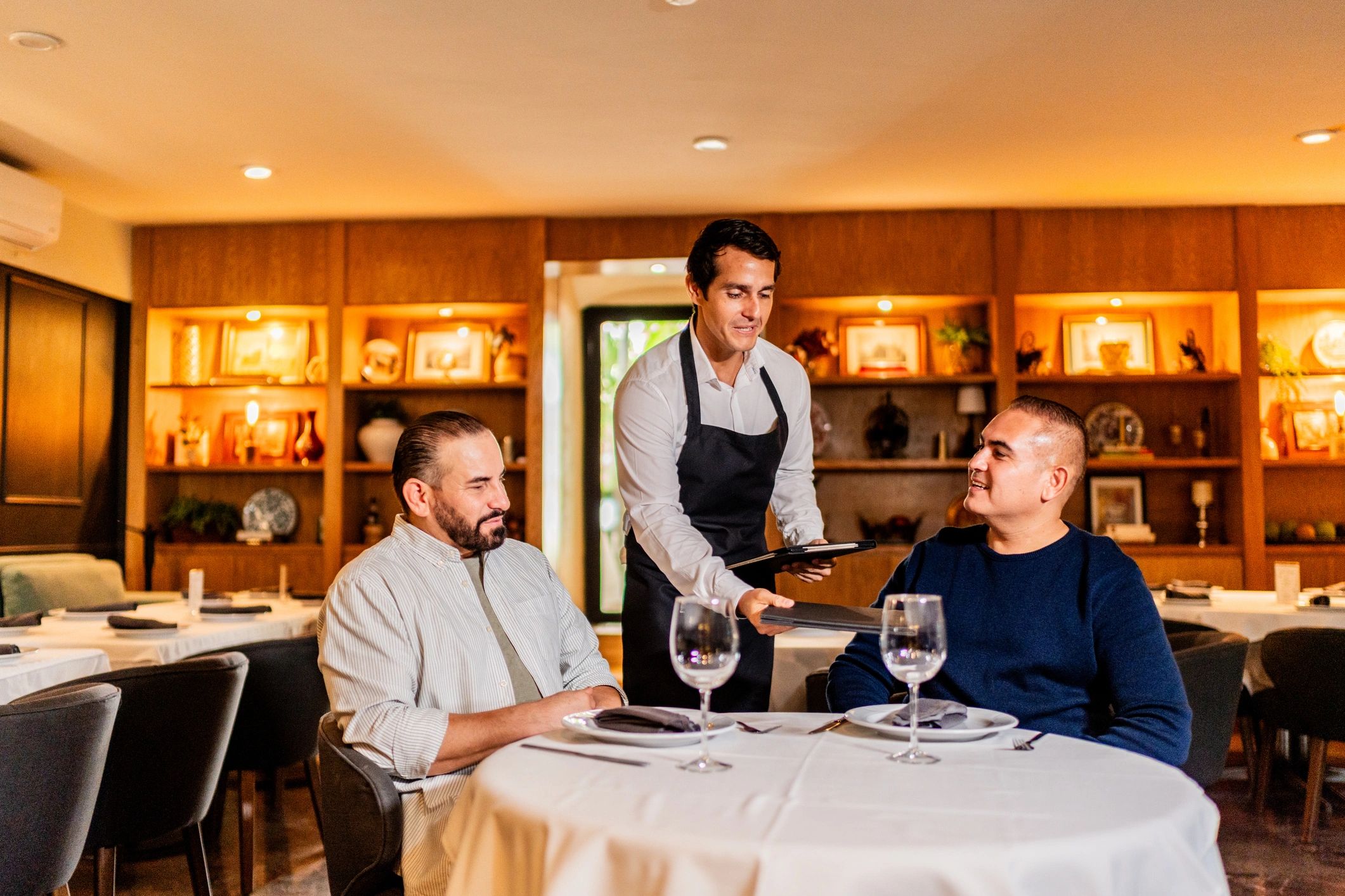 Restaurant staff serving guests in a dining setting